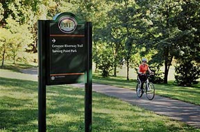 Photo of a person riding a bike on a trail.